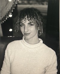 a black and white photo of a woman with curly hair